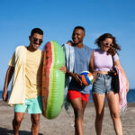 two men and a woman walking at the beach